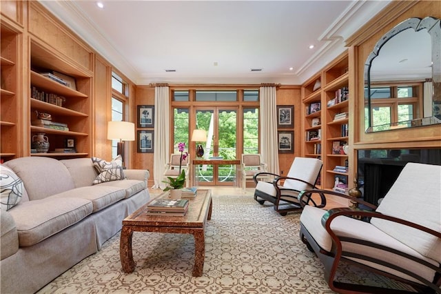 sitting room with built in features, crown molding, and french doors