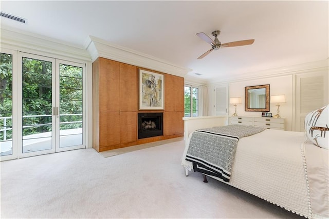 carpeted bedroom featuring ceiling fan, ornamental molding, access to outside, and multiple windows