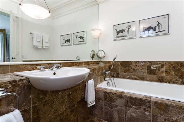 bathroom with ornamental molding, sink, and tiled bath