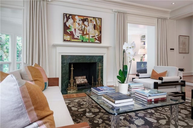 living room featuring a fireplace, hardwood / wood-style flooring, and crown molding