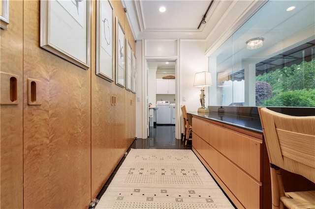 hallway with independent washer and dryer and crown molding