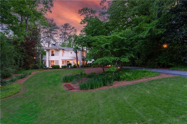 yard at dusk featuring a balcony