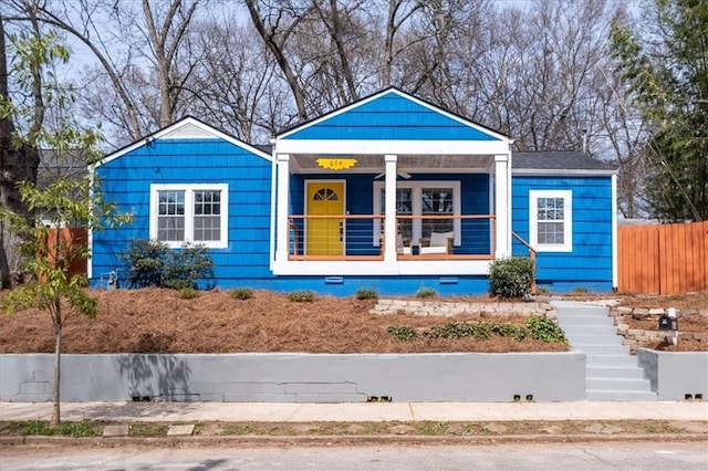 bungalow featuring a porch, a ceiling fan, and fence