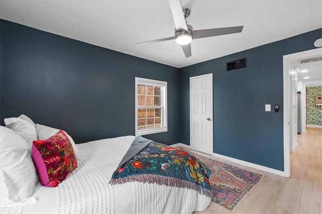 bedroom featuring wood finished floors, baseboards, visible vents, and ceiling fan