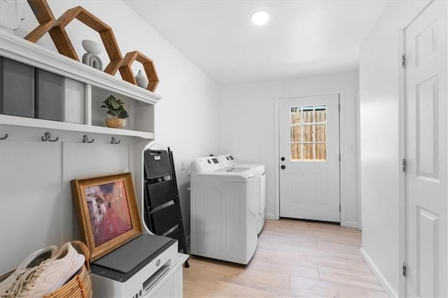 laundry area featuring baseboards, light wood finished floors, laundry area, recessed lighting, and washer and dryer