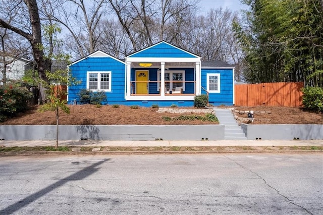 bungalow-style home with a porch and fence