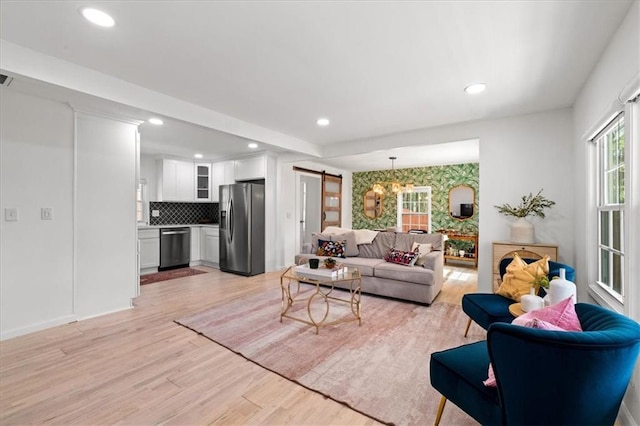 living room featuring a barn door, light wood-style flooring, and recessed lighting