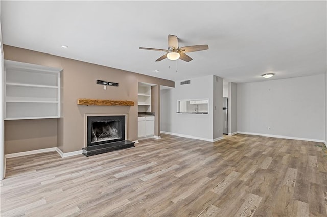 unfurnished living room with ceiling fan and light hardwood / wood-style flooring