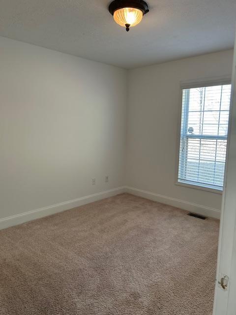 unfurnished bedroom with light colored carpet and a closet