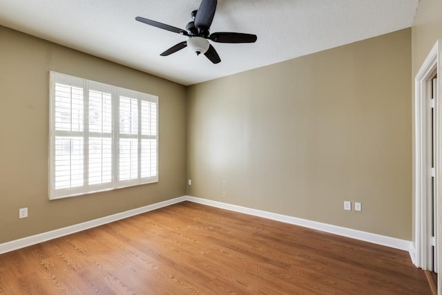 unfurnished room with ceiling fan, baseboards, and wood finished floors