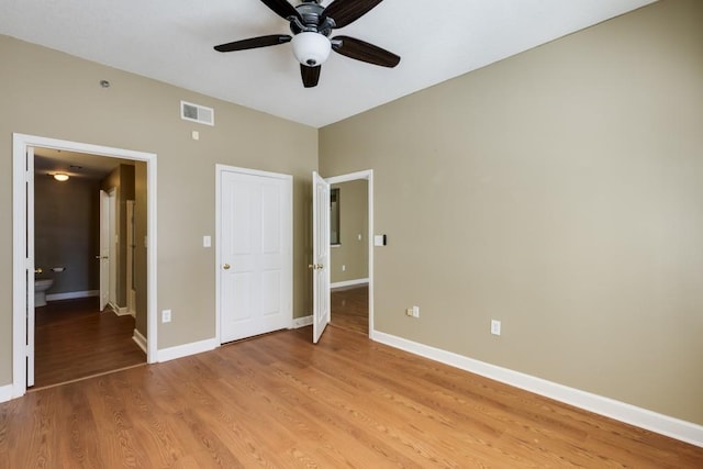 unfurnished bedroom featuring a ceiling fan, baseboards, visible vents, and light wood finished floors