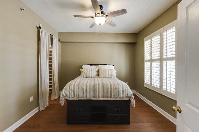 bedroom with multiple windows, baseboards, and wood finished floors