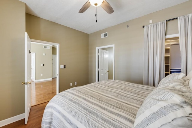 bedroom with visible vents, baseboards, and wood finished floors