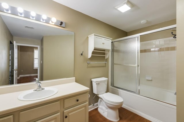 full bath with visible vents, toilet, wood finished floors, enclosed tub / shower combo, and vanity