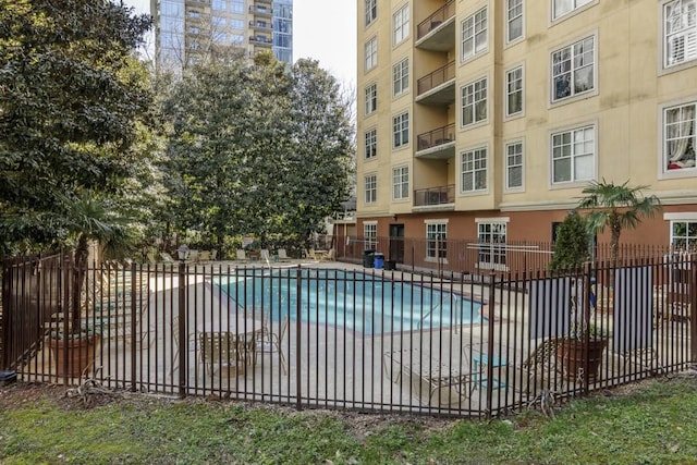 pool with a patio area and fence