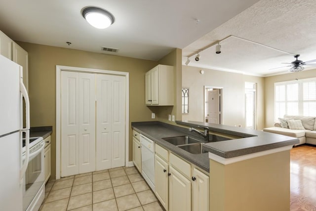 kitchen featuring dark countertops, visible vents, open floor plan, white appliances, and a sink