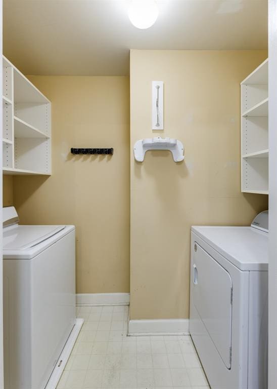 washroom featuring baseboards, independent washer and dryer, and laundry area