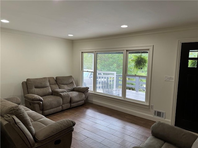 living room with wood-type flooring and ornamental molding