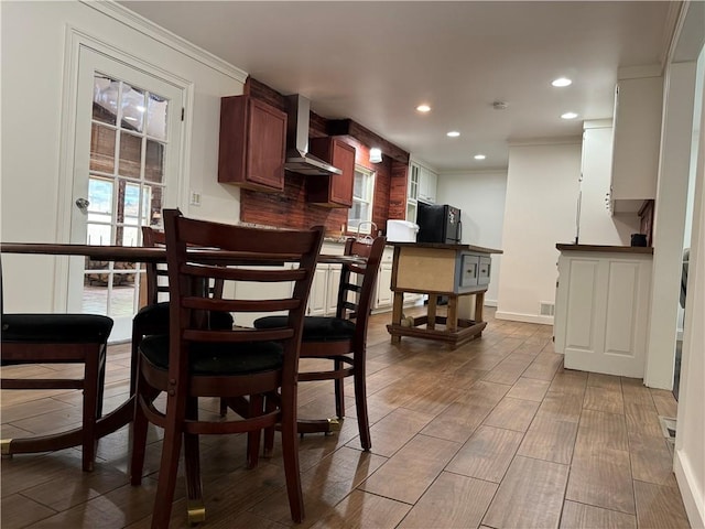 dining space with crown molding and hardwood / wood-style floors