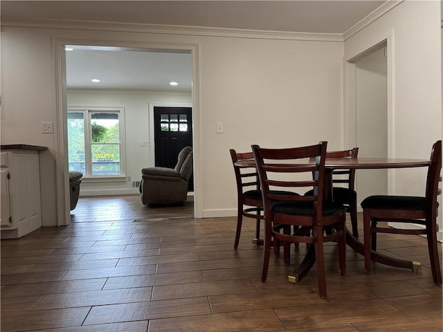 dining space with dark hardwood / wood-style flooring and crown molding