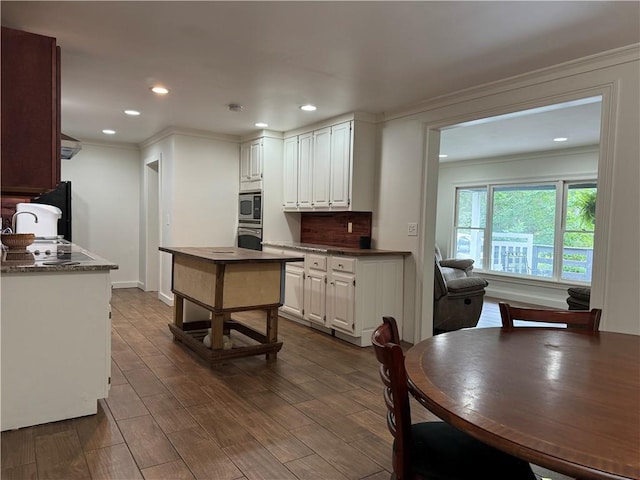 kitchen with white cabinetry, dark hardwood / wood-style floors, and crown molding