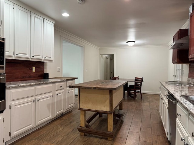 kitchen featuring white cabinetry, wall chimney range hood, stainless steel appliances, dark hardwood / wood-style flooring, and crown molding