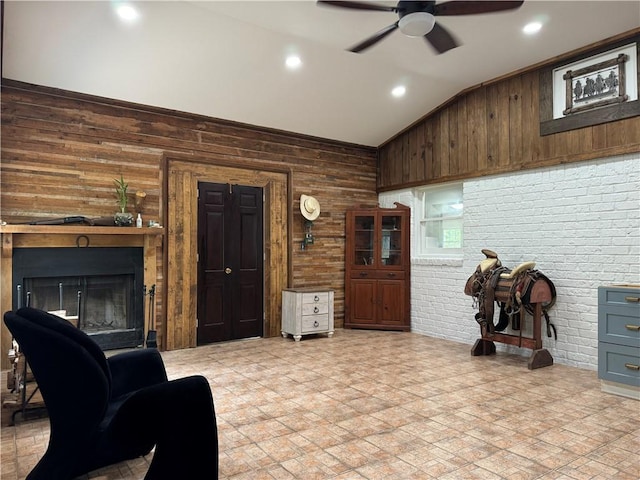 living room featuring brick wall, wooden walls, light tile patterned floors, and ceiling fan