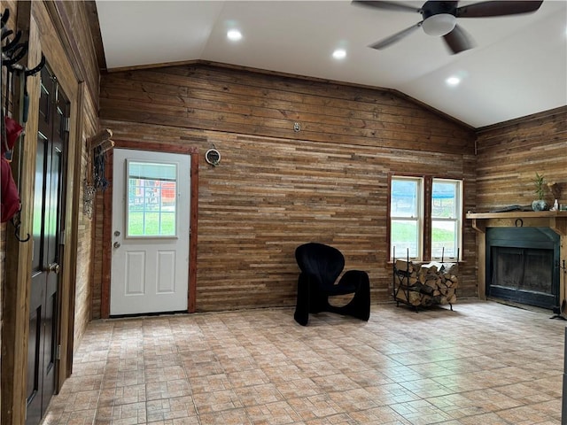 unfurnished room featuring vaulted ceiling, tile patterned floors, ceiling fan, and wooden walls