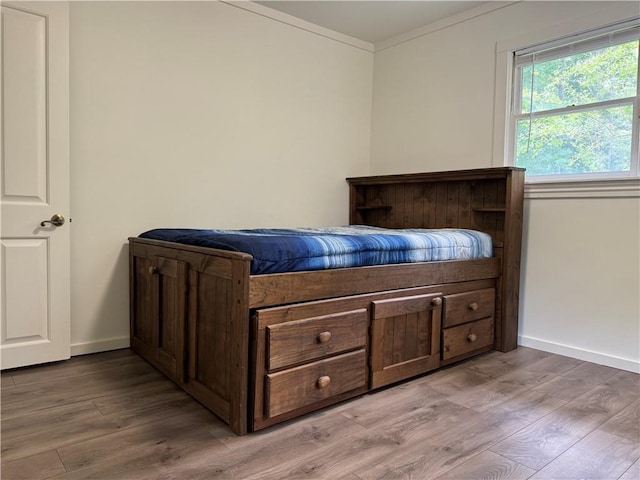 bedroom with hardwood / wood-style flooring and ornamental molding