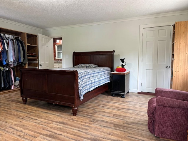 bedroom with crown molding, a textured ceiling, a closet, and wood-type flooring