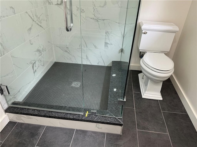 bathroom featuring an enclosed shower, tile patterned flooring, and toilet