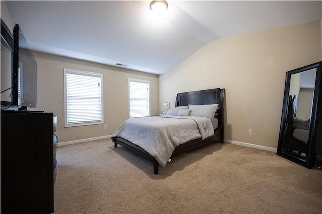 bedroom featuring light carpet and vaulted ceiling