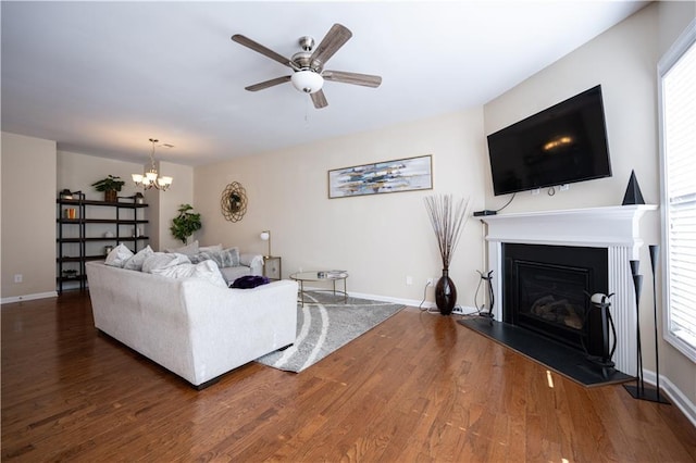 living room featuring dark wood-type flooring and ceiling fan with notable chandelier