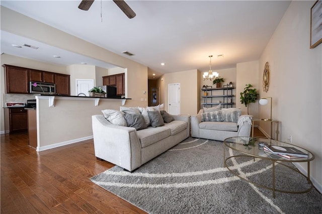 living room featuring dark wood-type flooring and ceiling fan with notable chandelier