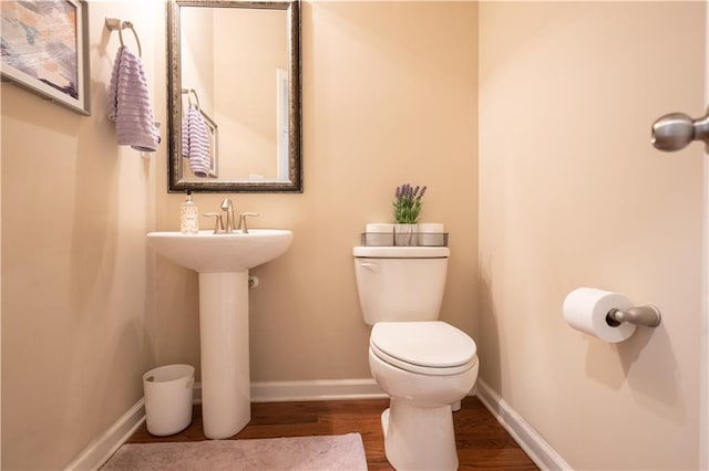 bathroom with hardwood / wood-style flooring and toilet