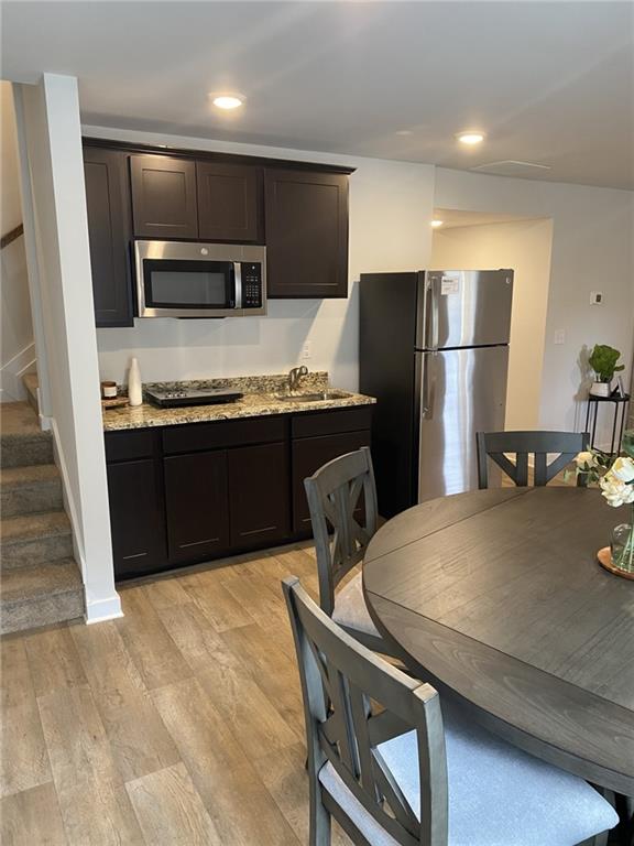 full bathroom with vanity, shower / bath combo, wood finished floors, and toilet