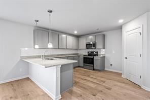 half bathroom with wood finished floors, toilet, and baseboards