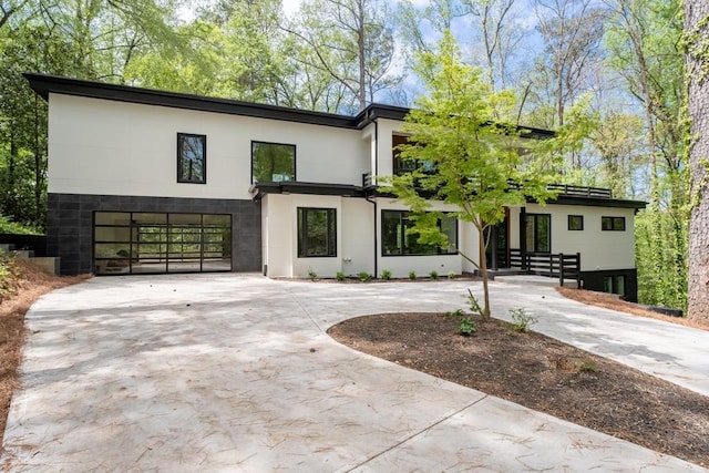 4366 Skyland Dr NE, Atlanta, GA 30342 - view of front of house featuring stucco siding, a garage, and curved driveway