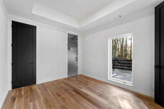 4366 Skyland Dr NE, Atlanta, GA 30342 - empty room with light wood finished floors, baseboards, visible vents, and a raised ceiling