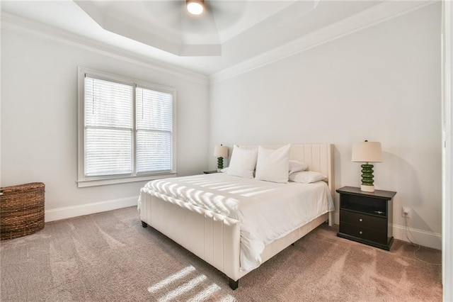 carpeted bedroom with a raised ceiling, crown molding, and ceiling fan