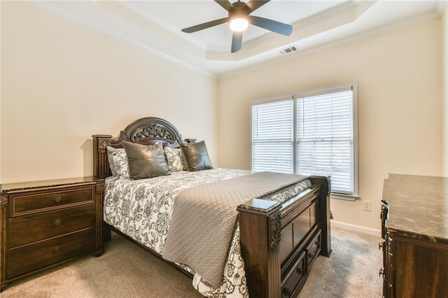 carpeted bedroom with a raised ceiling, crown molding, and ceiling fan