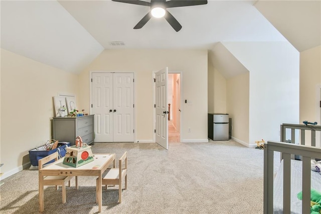 interior space with ceiling fan, vaulted ceiling, and light carpet