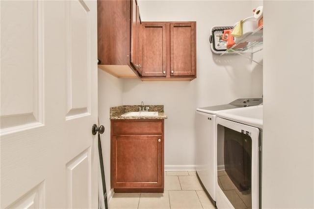 washroom featuring sink, light tile patterned floors, cabinets, and washing machine and clothes dryer