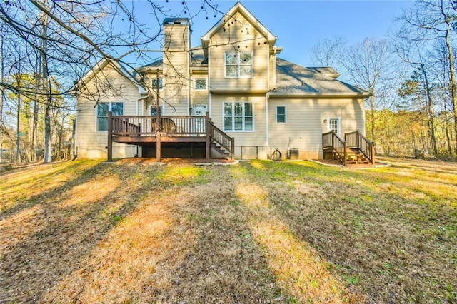 rear view of property with a wooden deck and a lawn