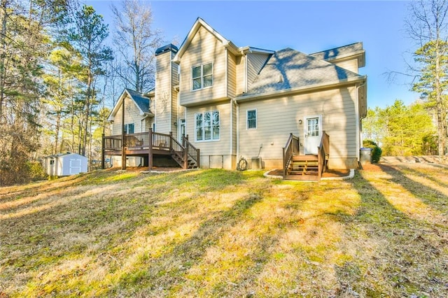 rear view of property featuring a yard, a deck, and a storage unit