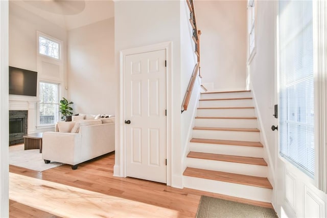 stairway with hardwood / wood-style flooring and a towering ceiling