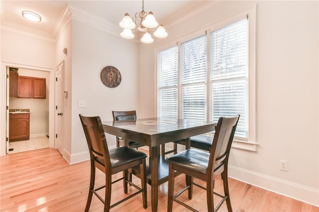 dining area featuring an inviting chandelier, ornamental molding, and light hardwood / wood-style flooring