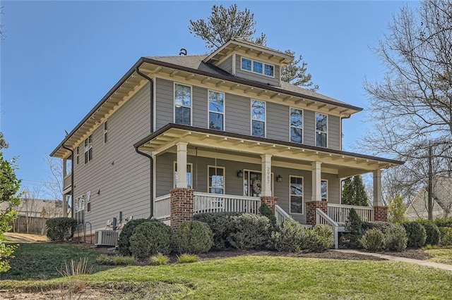 american foursquare style home featuring a porch, central AC, and a front yard