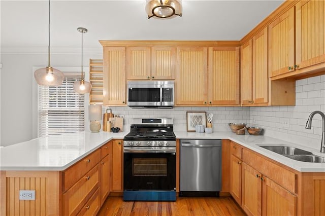 kitchen featuring sink, stainless steel appliances, decorative backsplash, and hanging light fixtures