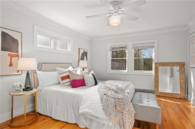 bedroom featuring ornamental molding, light wood-type flooring, and ceiling fan